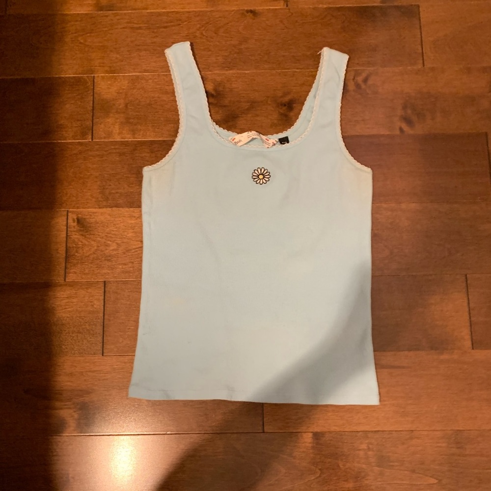 Light blue tank top with white sunflower in the center. Still in good condition